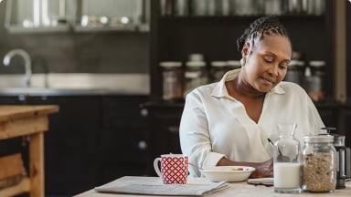 Personne assise à une table avec de la nourriture et une boisson.